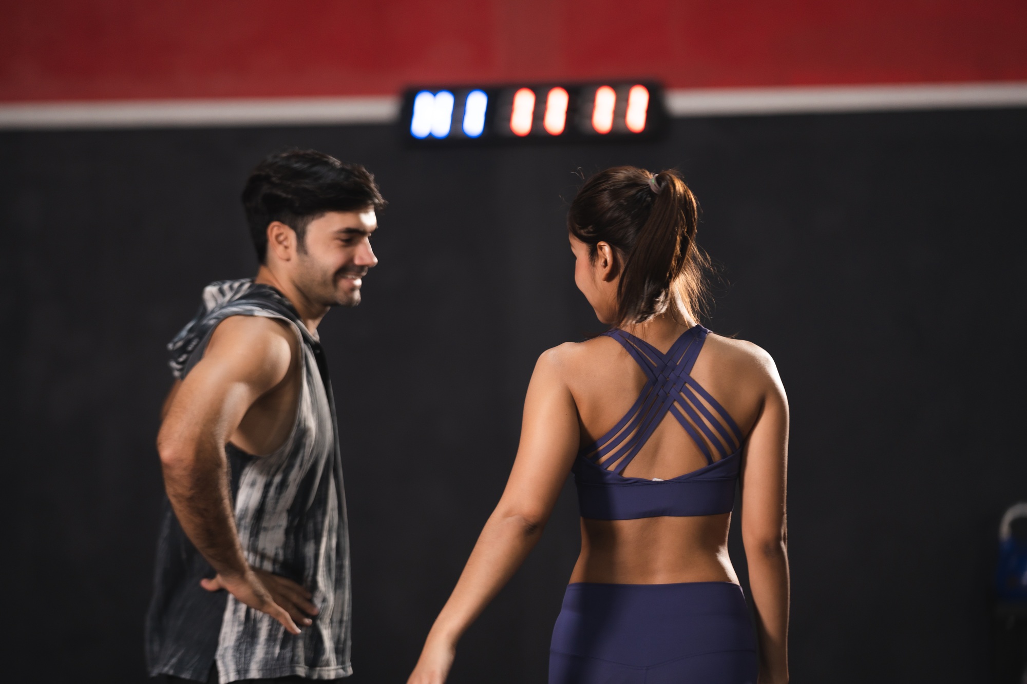 Personal trainer coach helping young woman exercising in the sport gym, exercise training