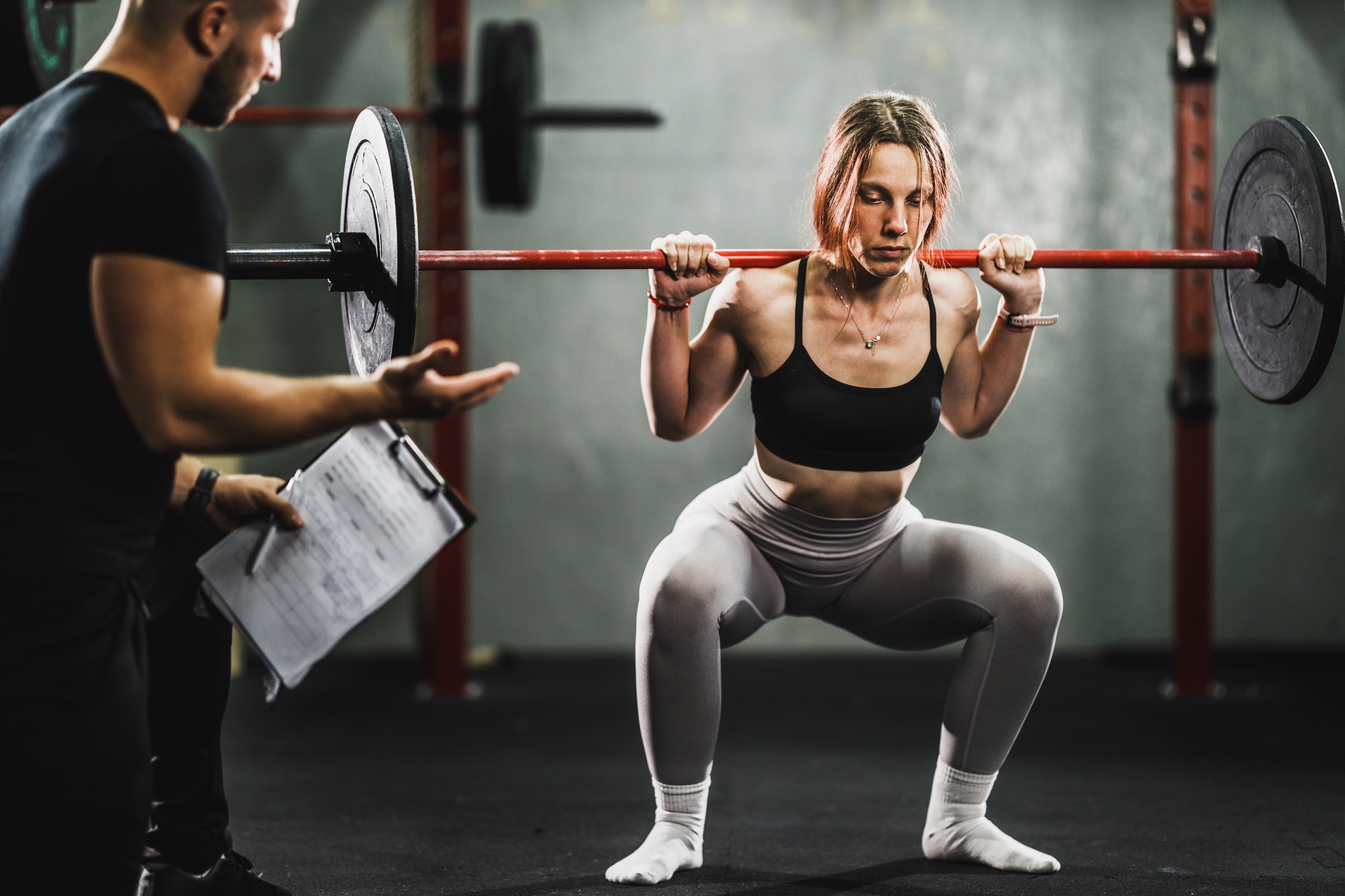 Woman Exercising With Personal Trainer At The Gym